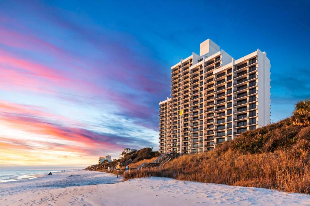 a tall building on the beach next to a sandy beach at One Seagrove Place 0908 in Santa Rosa Beach