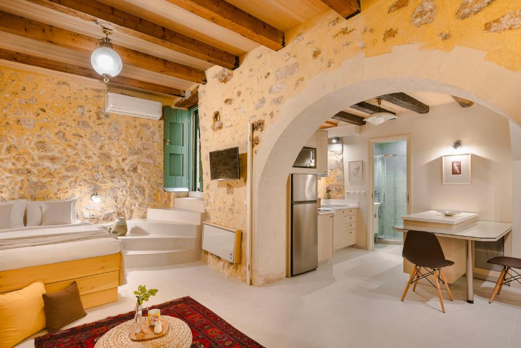 a bedroom with a stone wall and a bed and a desk at Giota's House in Chania Town