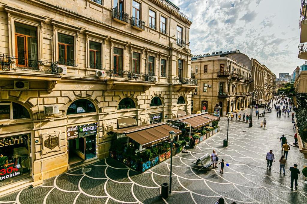 a group of people walking around a city street at Apartment AERİA in Baku