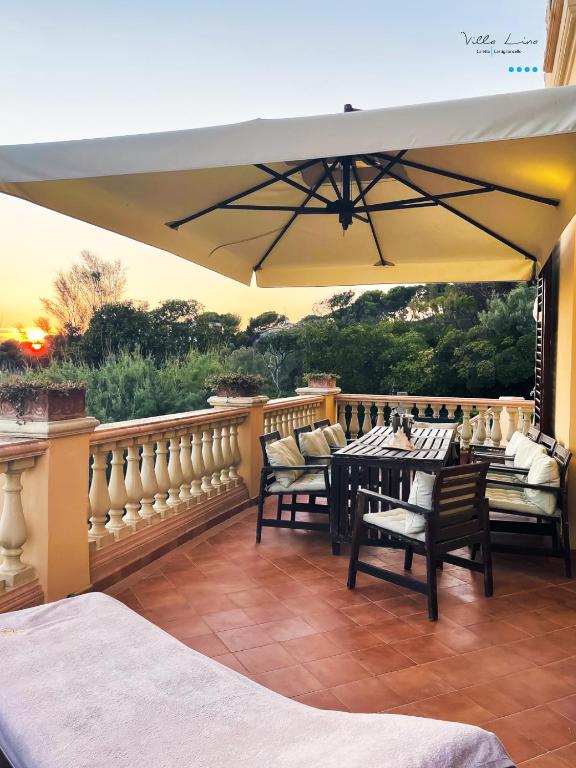 a patio with a table and chairs and an umbrella at Villa Lina in Castiglioncello