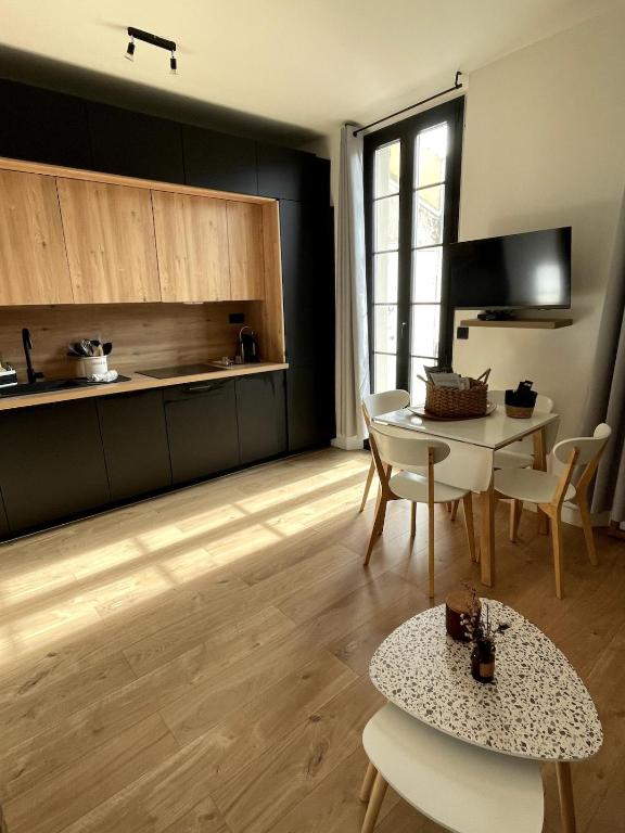 une cuisine avec une table et des chaises dans une pièce dans l'établissement Marlène Coeur Vieil Antibes, quartier sympa, rénové et convivial , clim, balcon, à Antibes