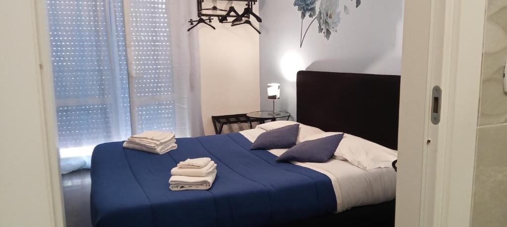 Un dormitorio con una cama azul con toallas. en B&B La Fenice, en Pompeya