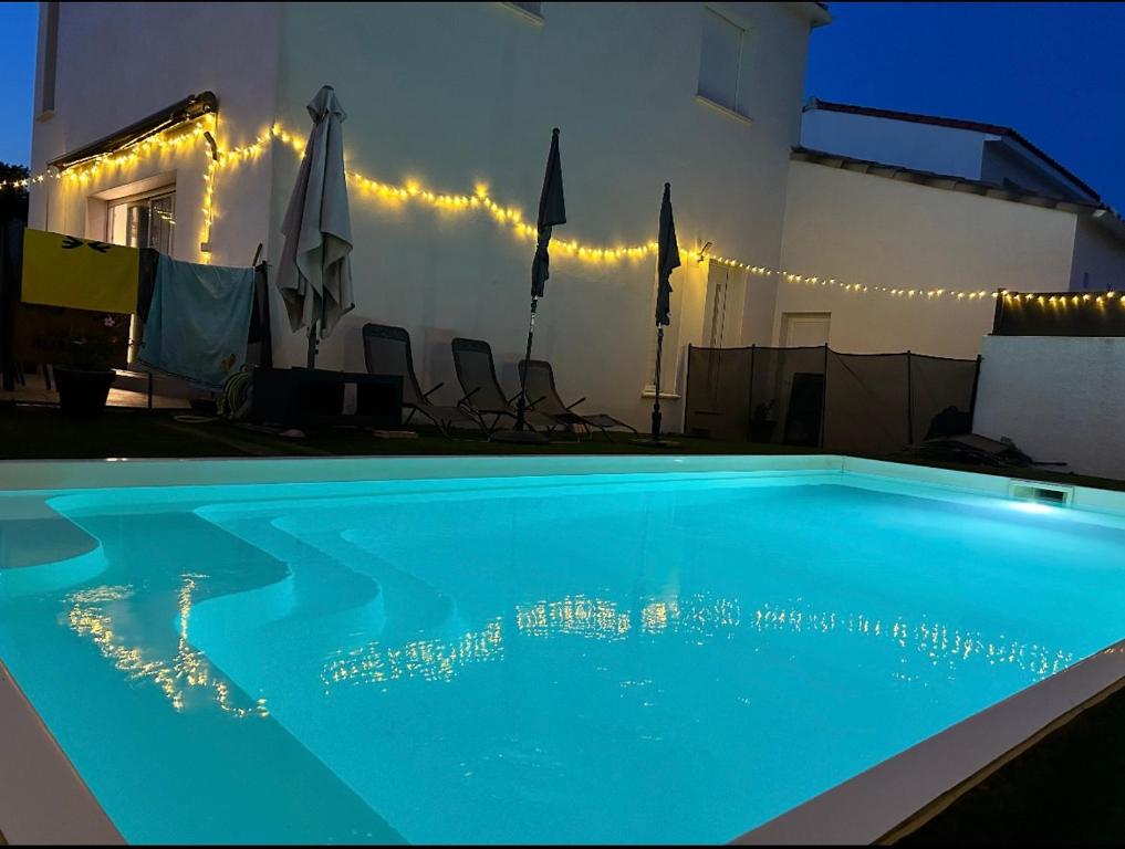 une piscine devant une maison la nuit dans l'établissement Villa piscine barbecue, à Codognan