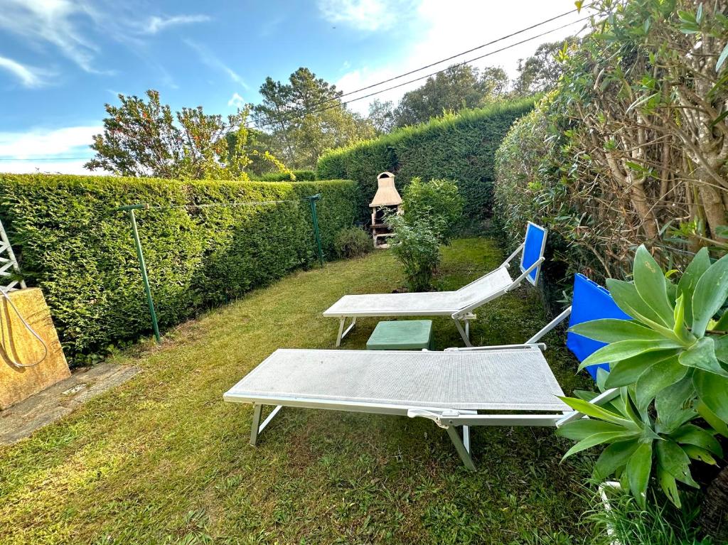 un banc, une table et une chaise dans la cour dans l'établissement Mini-villa située à 5 minutes de la plage de Pinarello à pieds, à Pinarellu