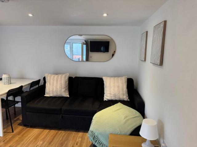 a living room with a black couch and a table at Valletta House Holiday Apartments in Skegness