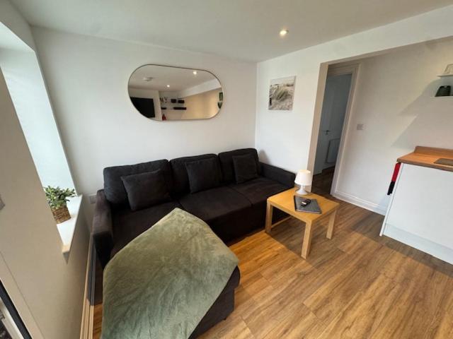 a living room with a black couch and a table at Valletta House Holiday Apartments in Skegness