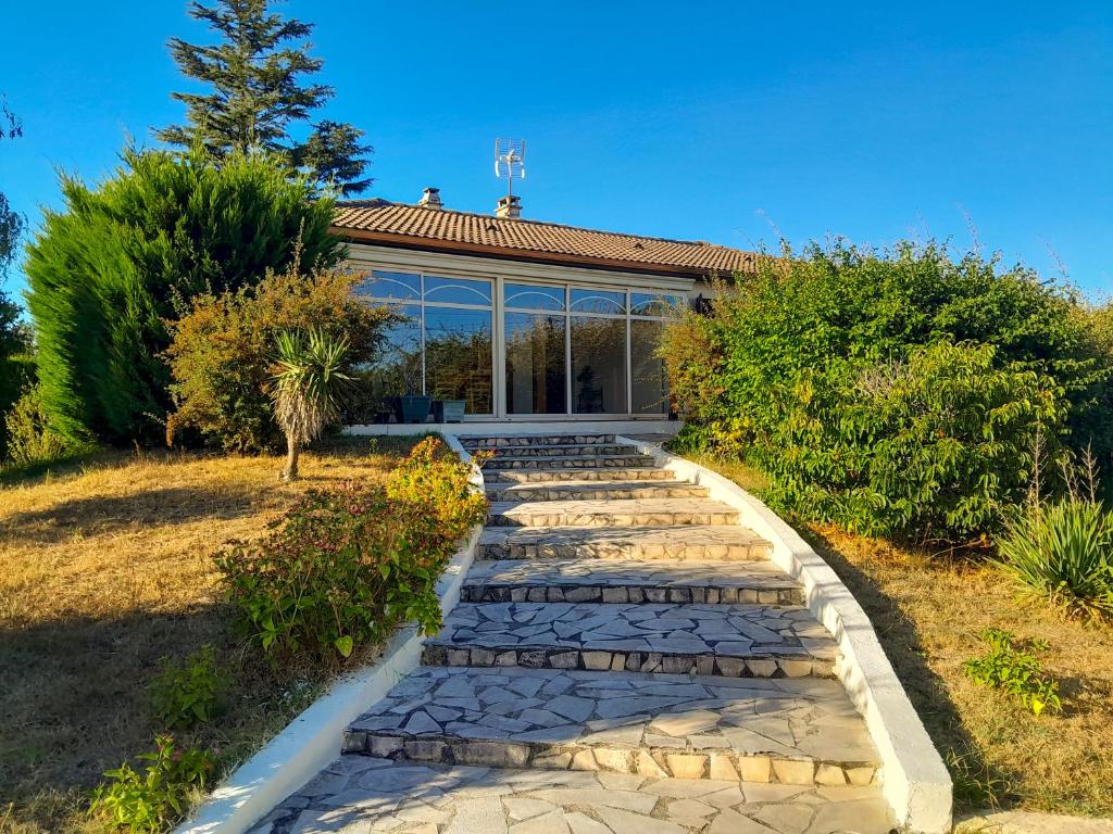 a stone path in front of a house at L'Evasion, maison spacieuse, véranda, parking in Saint-André-de-Cubzac