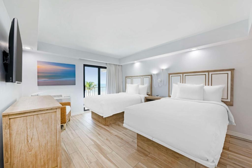 a hotel room with two beds and a television at Best Western Plus Beach Resort in Fort Myers Beach