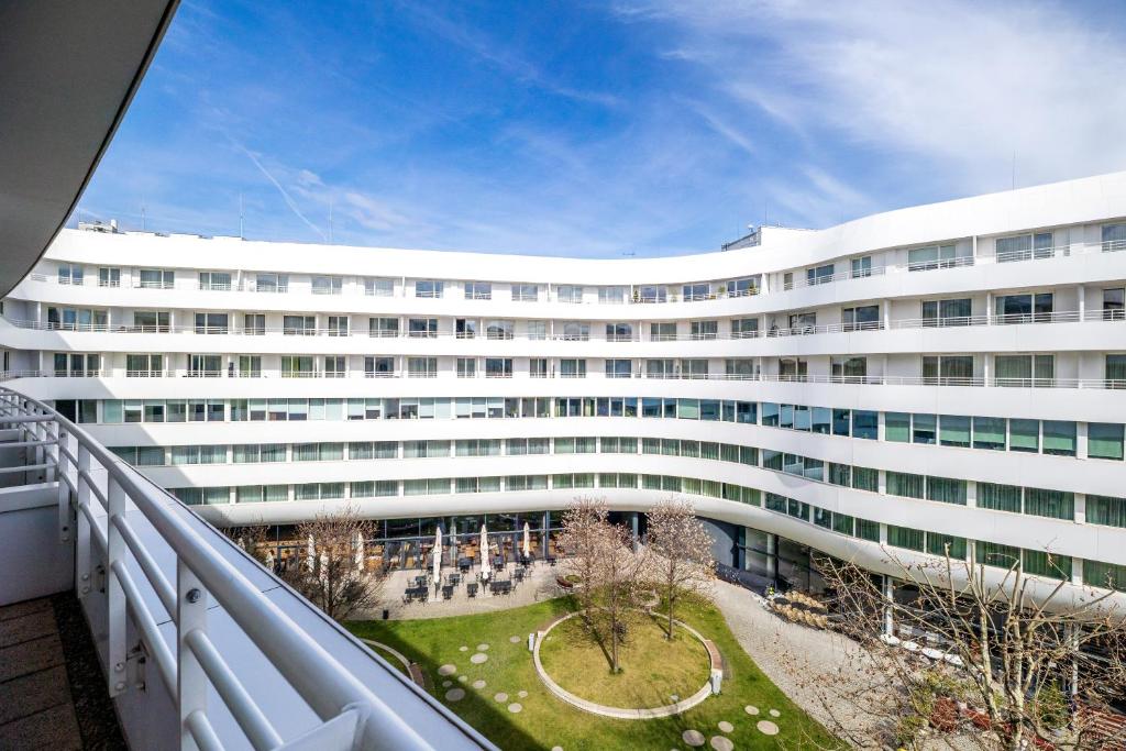 Un gran edificio blanco con un patio delante. en About Art Apartments - Ovo, en Wroclaw