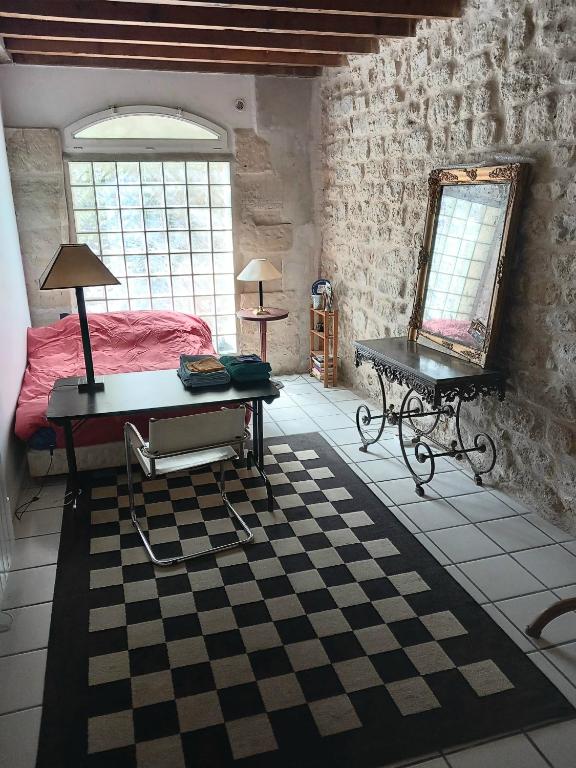 une chambre avec un lit, une table et un miroir dans l'établissement Charmant loft dans maison ancienne, à Carrières-sur-Seine