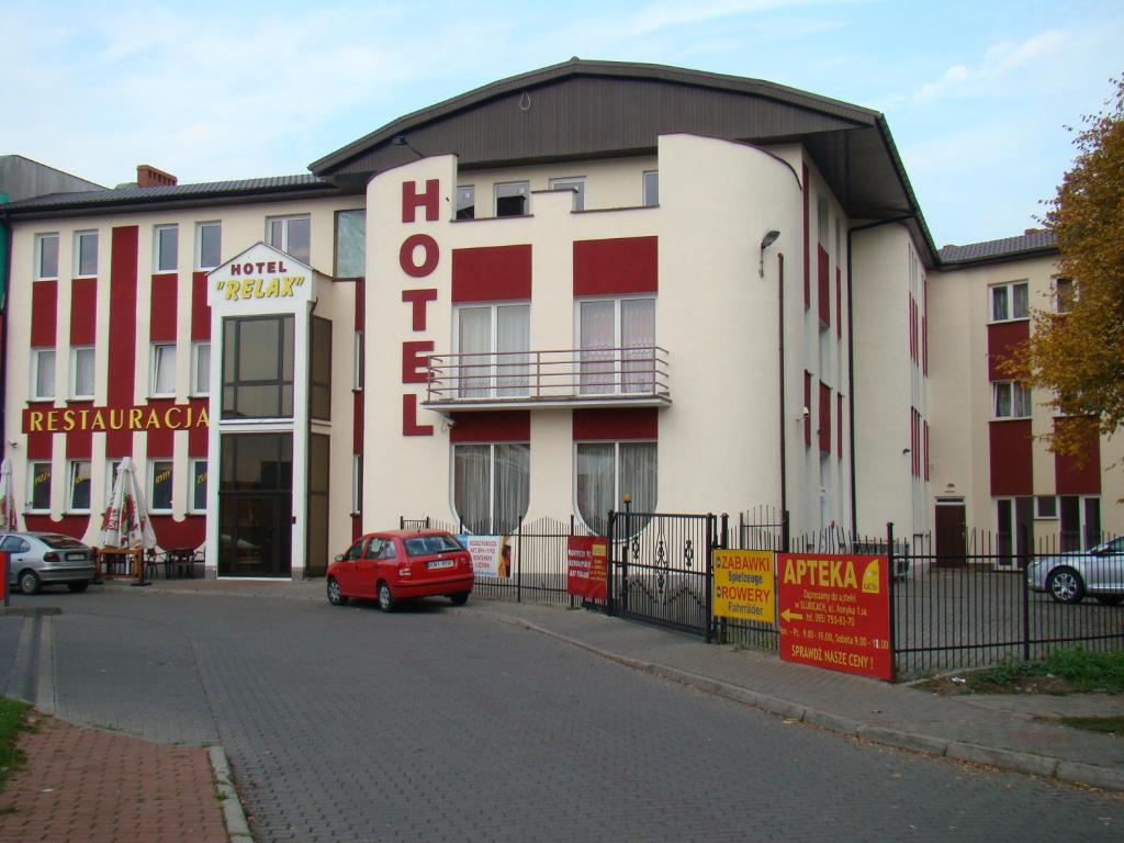 een rode auto geparkeerd voor een gebouw bij Hotel Relax in Słubice