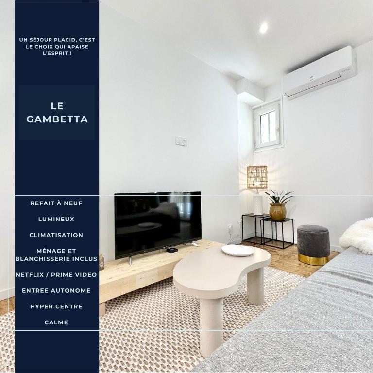 Cette chambre comprend un lit, une télévision et une table. dans l'établissement Le Gambetta - Central - Clim - Balcon - Spacieux, à Mont-de-Marsan