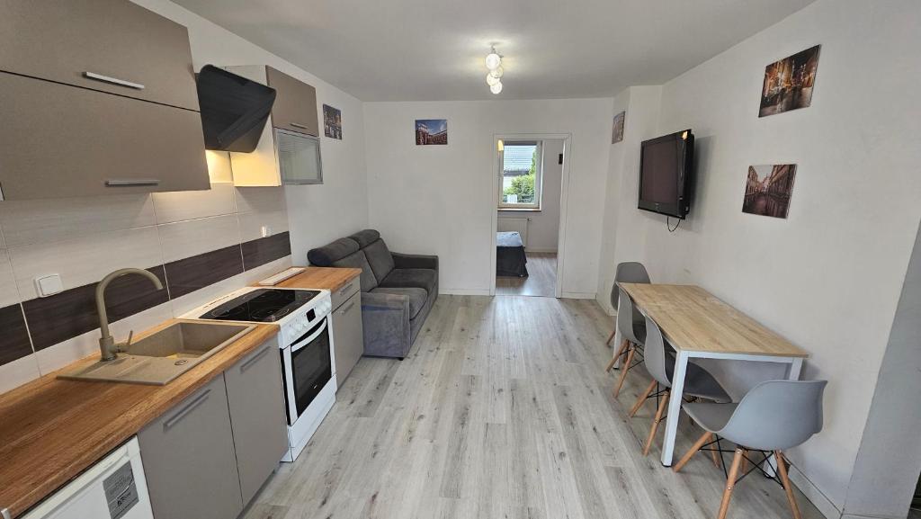 a kitchen and living room with a couch and a table at Apartament przy Sosnowej in Lublin