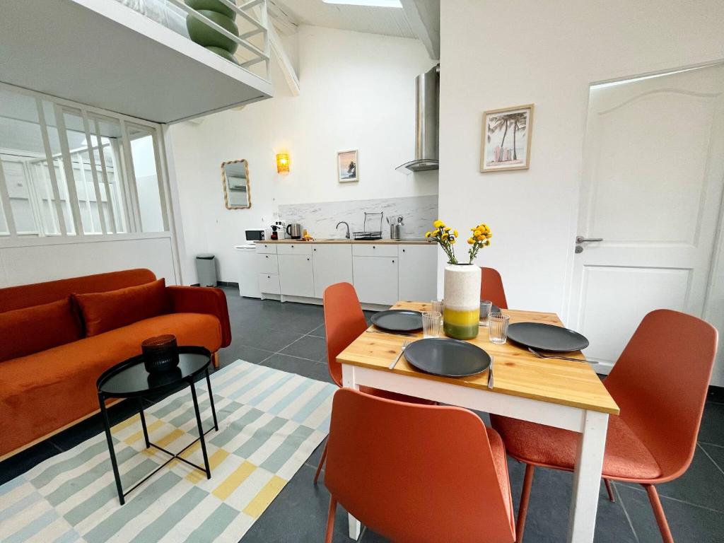 un salon avec une table, des chaises et un canapé dans l'établissement Suite Springs - Check in h24 - Wifi, à Villeurbanne