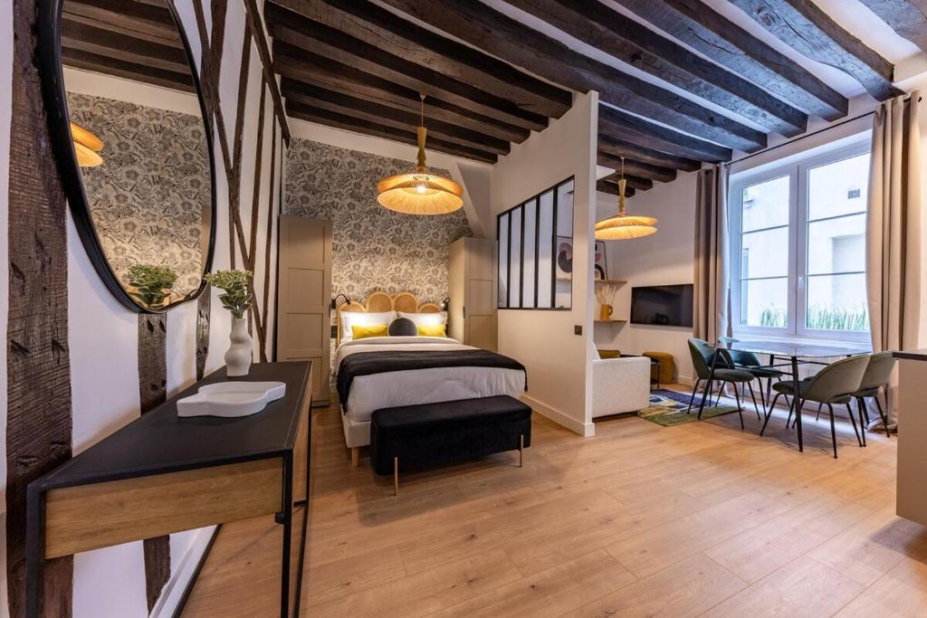 une chambre avec un lit, une table et des chaises dans l'établissement Parisian Luxury Living rue Dauphine Saint-Germain-des-Prés, à Paris