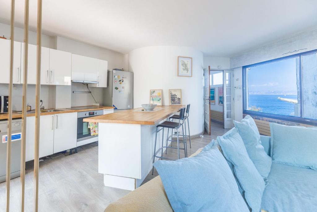 - une cuisine et un salon avec un canapé et un comptoir dans l'établissement L'Escapade Méditerranéenne, à Marseille