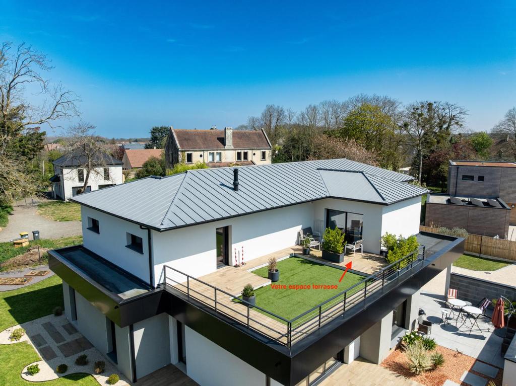 une vue aérienne d'une maison avec un toit dans l'établissement appartements guesthouse1 et guesthouse2 sword beach, à Colleville-Montgomery