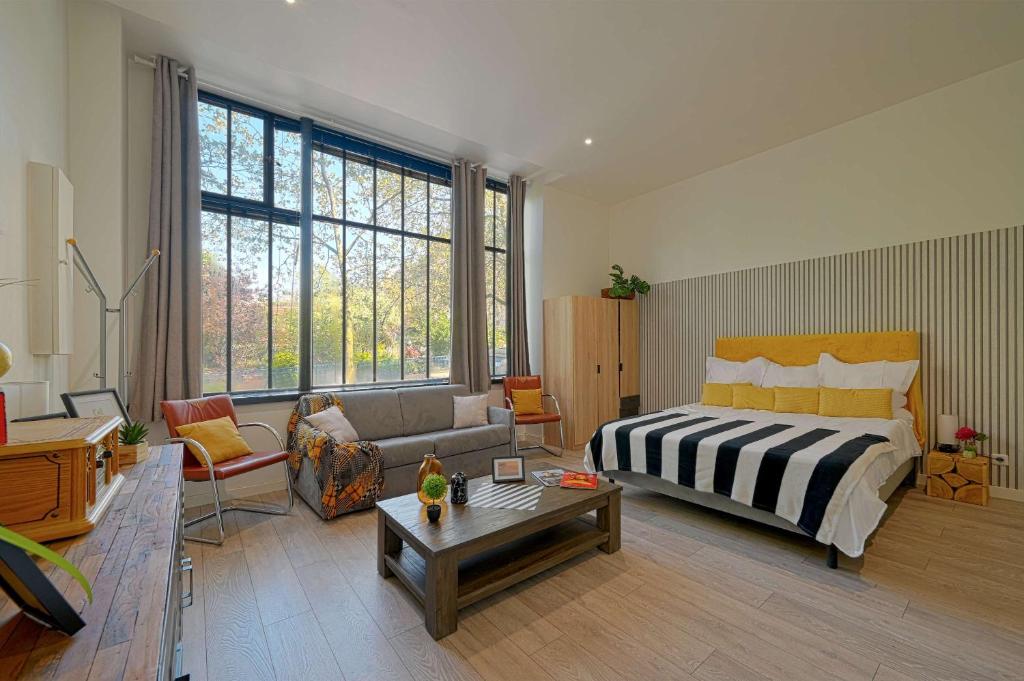 une chambre avec un lit et un salon avec un canapé dans l'établissement Cosy Studio proche gare de Lyon, à Paris
