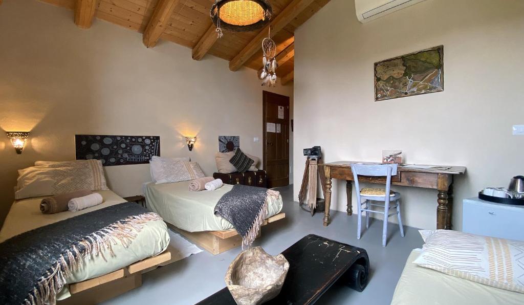 pokój z dwoma łóżkami i stołem w obiekcie Agrilunassa Eco GuestHouse and Cottage w mieście Bordighera
