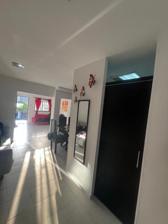 a living room with a mirror and a chair in a room at Casa grande cerca a la playa in Ríohacha