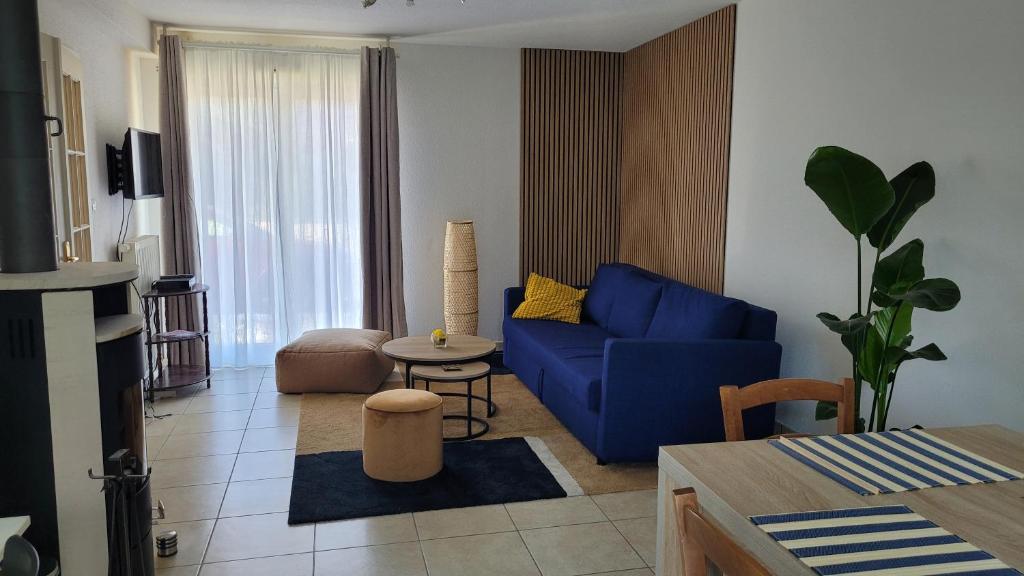 a living room with a blue couch and a table at La petite maison du Florival in Guebwiller