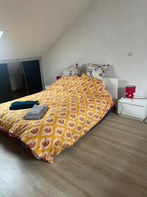 a bedroom with a bed with a yellow comforter at Gainsbourg in Ouroux-sur-Saône