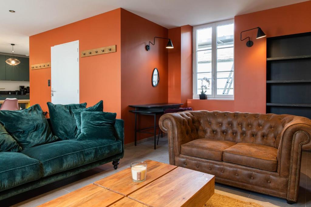 un salon avec deux canapés en cuir et une table dans l'établissement Chambre dans maison cosy, à Château-Gontier