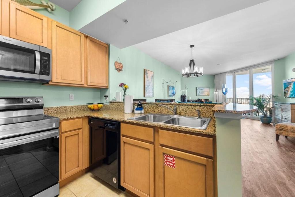 eine Küche mit Spüle und Mikrowelle in der Unterkunft 5 Star Resort 11th Fl Stunning Sunrise 2BR 2BA King Suite,Pools ,Shuttle or Walk to Beach in Destin