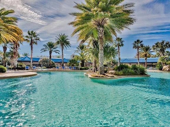 a swimming pool with palm trees in a resort at 5 Star Resort 11th Fl Stunning Sunrise 2BR 2BA King Suite,Pools ,Shuttle or Walk to Beach in Destin