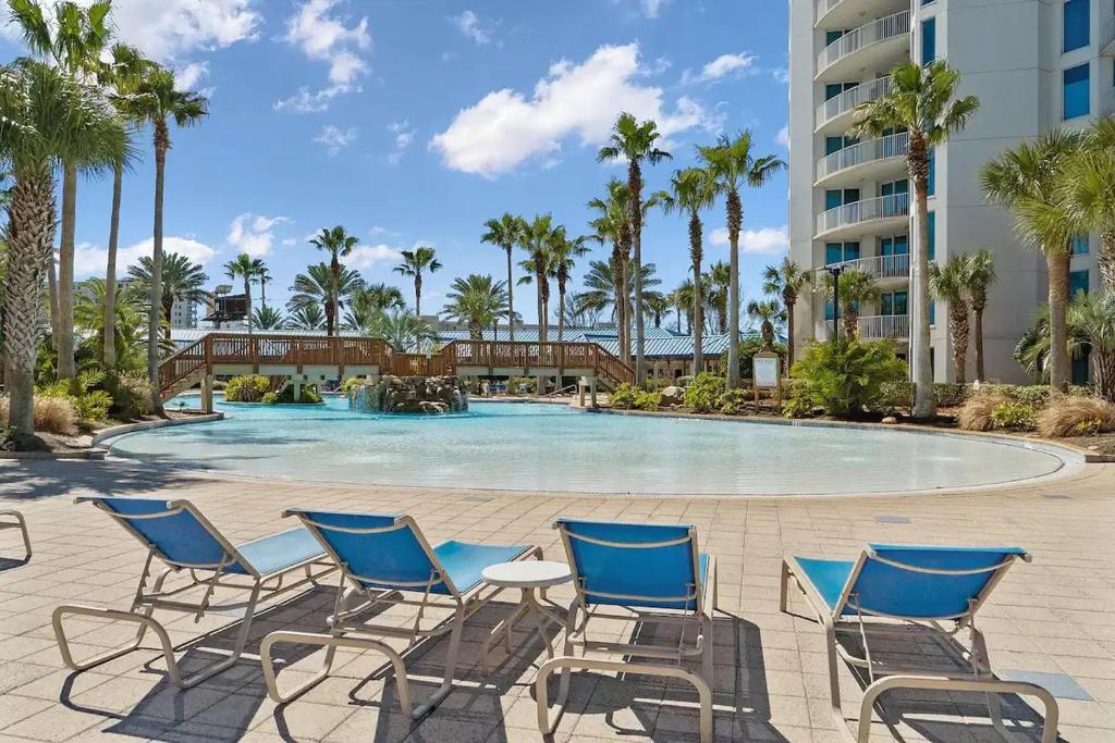 a swimming pool with chairs and a building at 5 Star Resort 11th Fl Stunning Sunrise 2BR 2BA King Suite,Pools ,Shuttle or Walk to Beach in Destin