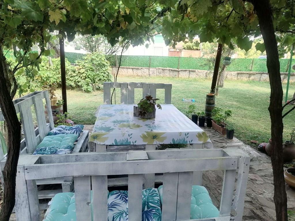a white table and chairs in a yard with a table at Guest House RUSALIA in Gara Oreshets