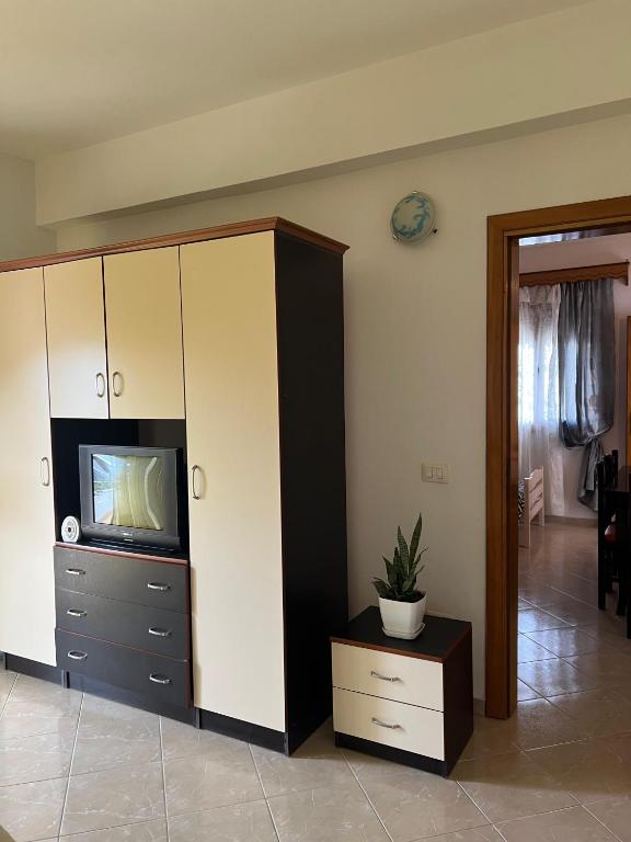a living room with a tv and a cabinet at Dario's Apartaments in Orikum