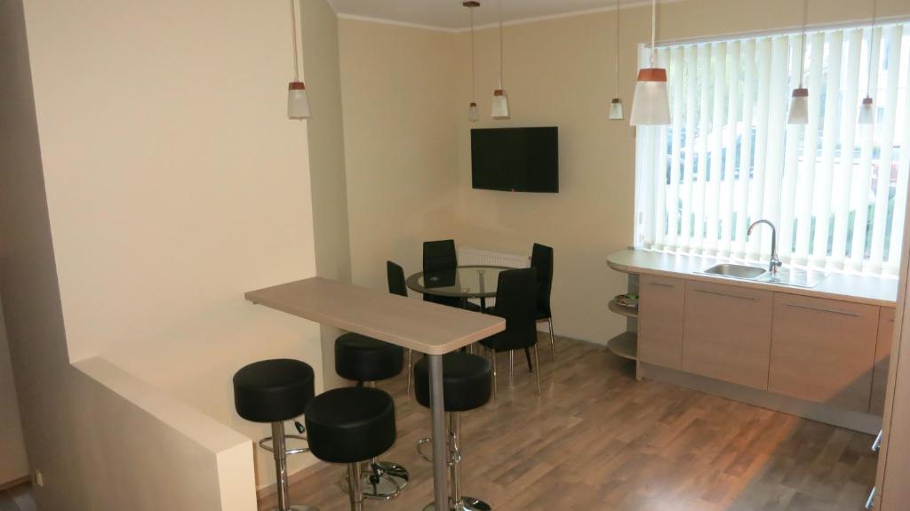 a kitchen and dining room with a table and chairs at Cat Garden Premium Apartments Riga in Rīga