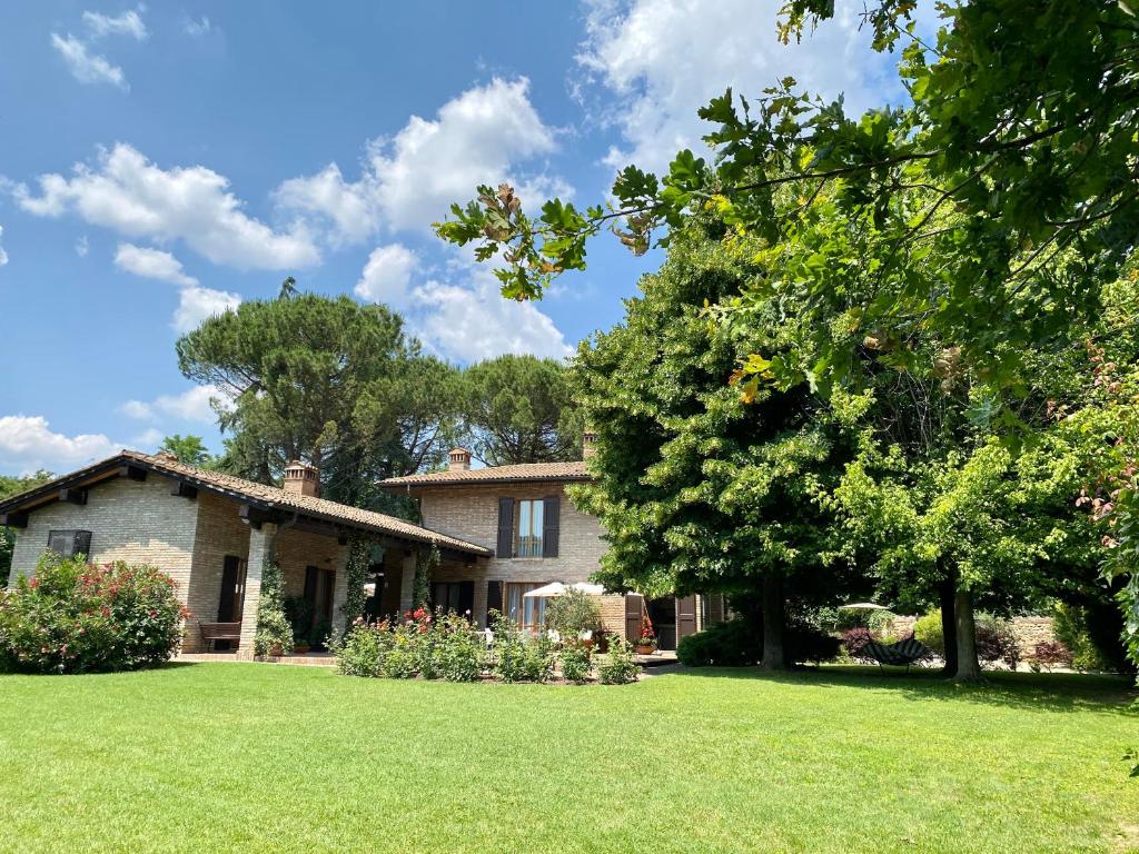 una casa con un patio verde con un árbol en Pozzo Di Mezzo B&B, en Bolonia