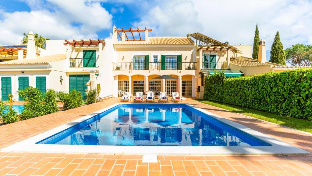 une villa avec piscine devant une maison dans l'établissement Vilamoura - VILLA LIMONI, à Vilamoura