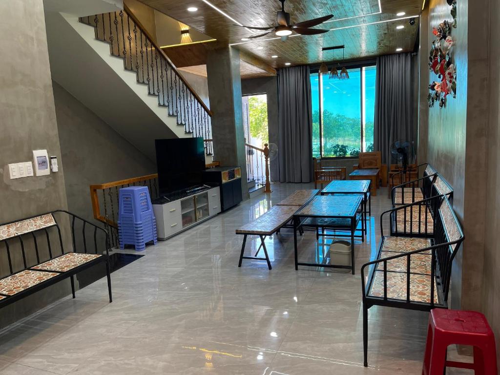 una stanza con tavoli e sedie e una scala di Sea Home - Mui Ne Summerland 4br a Phan Thiet