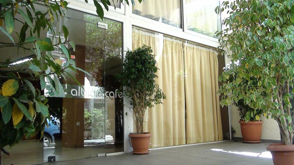 eine Lobby mit Pflanzen in Töpfen in einem Gebäude in der Unterkunft Albion in Athen