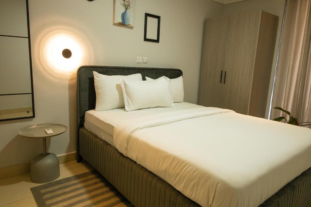 a bedroom with a bed with white sheets and pillows at The Pinnacle Apartment, Bar and Lounge in Otinshi
