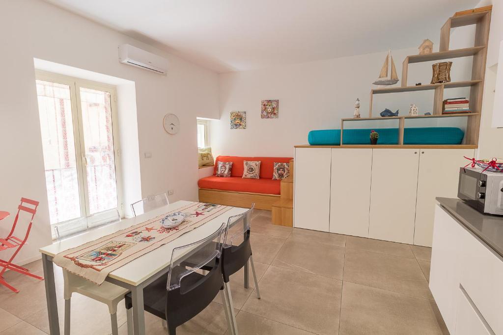 a kitchen and living room with a table and a couch at LA PERLA in Cefalù