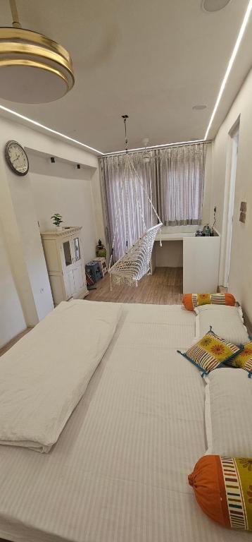 a large white bed in a room with a clock at Shanti Niwas Jodhpur, Rajasthan in Jodhpur