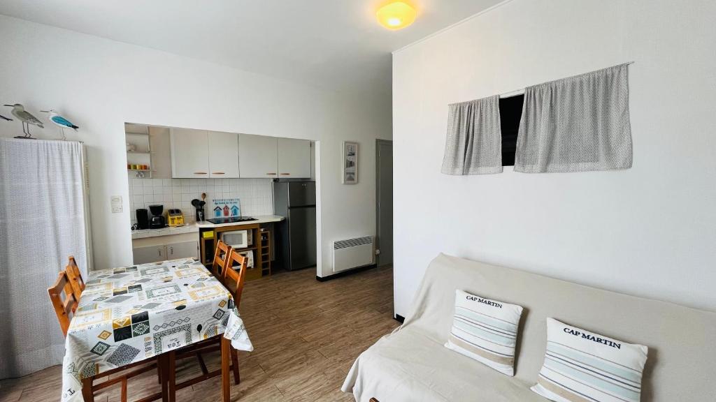 un salon avec une table et une cuisine dans l'établissement Appart des Tamaris, 200m de la plage, à Saint-Jean-de-Monts