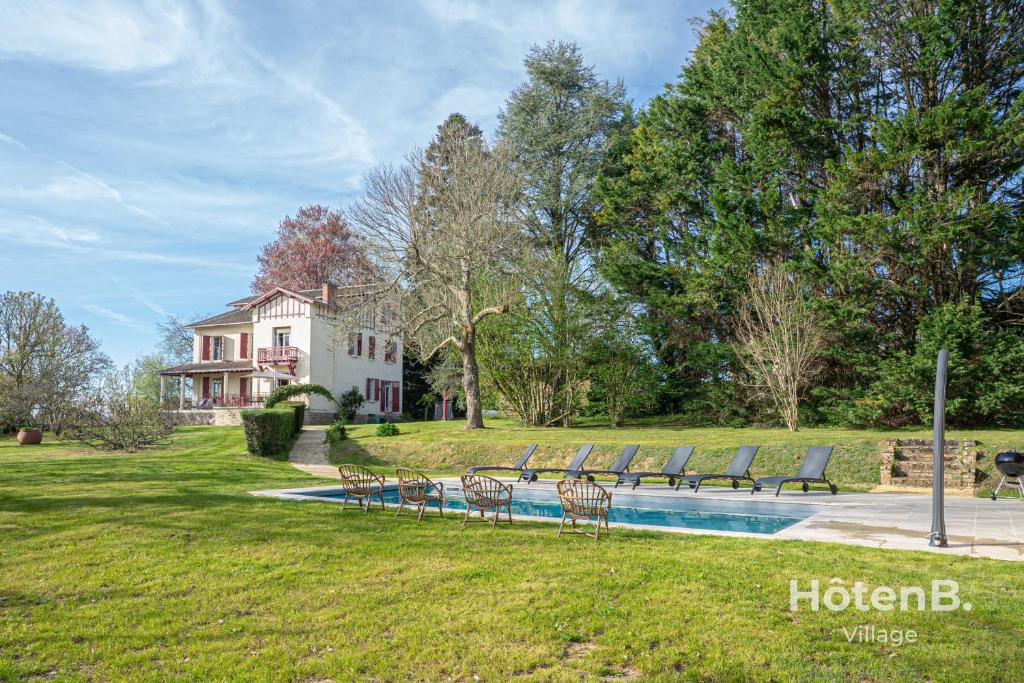 un gruppo di sedie sedute accanto a una piscina di Maison Léonce Blanc - Prestige in Lubersac a Lubersac