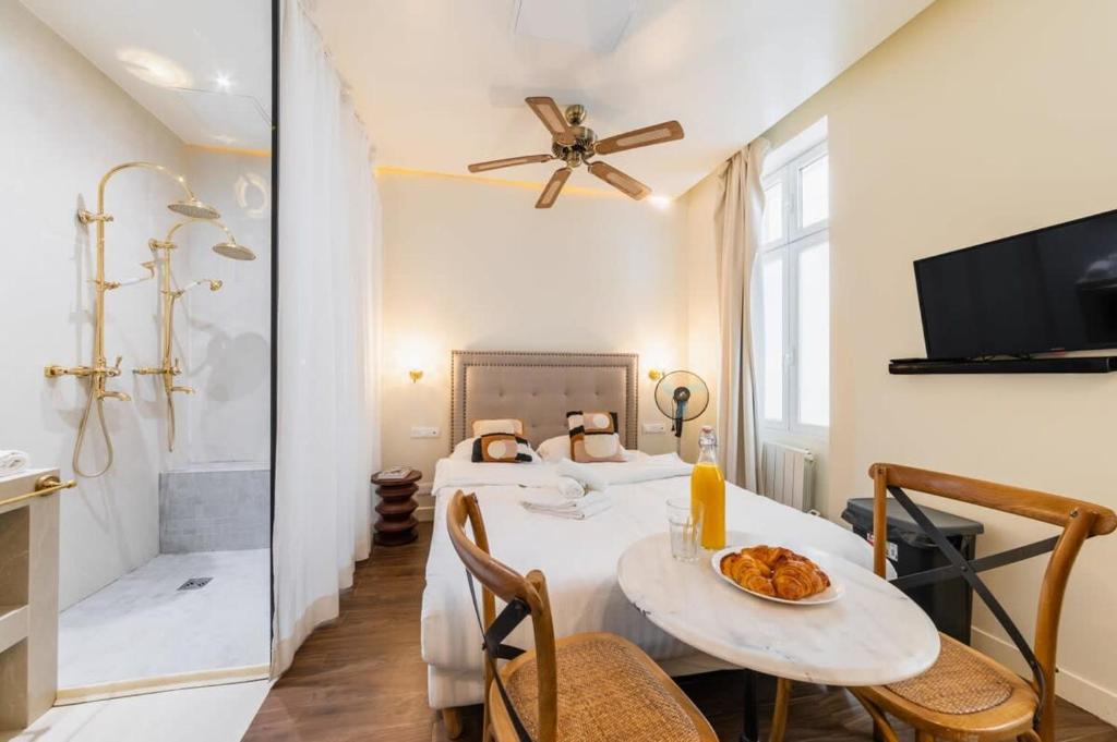 Cette chambre comprend deux lits et une table avec une assiette de nourriture. dans l'établissement Studio de charme quartier tour eiffel - 2P, à Paris