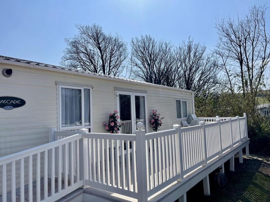 a white mobile home with a white fence at South Bay Hideaway, Brixham in Brixham