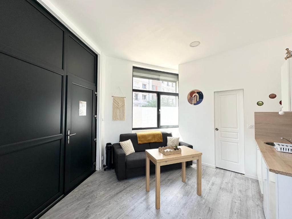 un salon avec un canapé et une table dans l'établissement Le Francis, petit studio proche métro A, à Villeurbanne