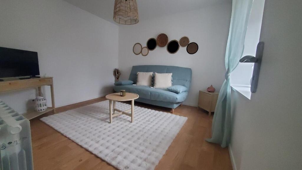 a living room with a blue couch and a table at appartement Le bohème in Fère-en-Tardenois