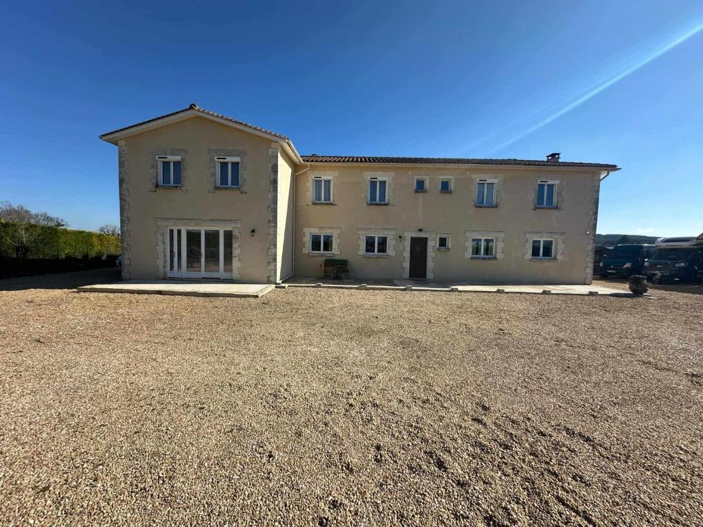a large white house on a gravel lot at Le Clos de Bourdeilles chambre 2 avec wifi in Bourdeilles