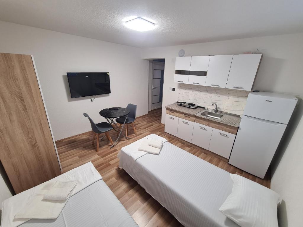 a room with a bed and a kitchen with a table at Solar Residence Rooms in Prilep