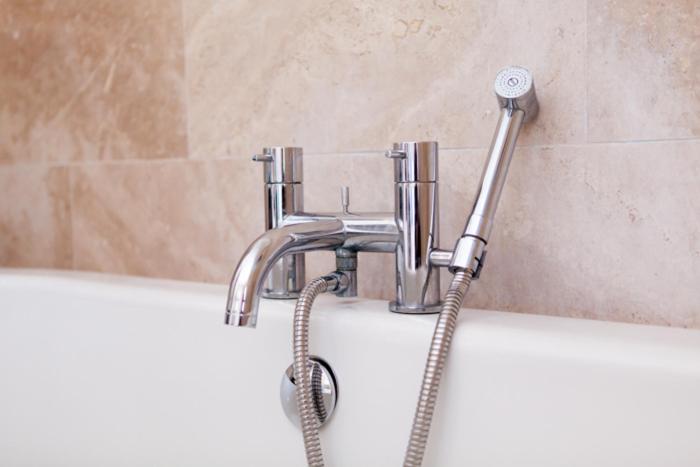 a shower head in a bath tub with a hose at Birch House Bed & Breakfast in Weymouth