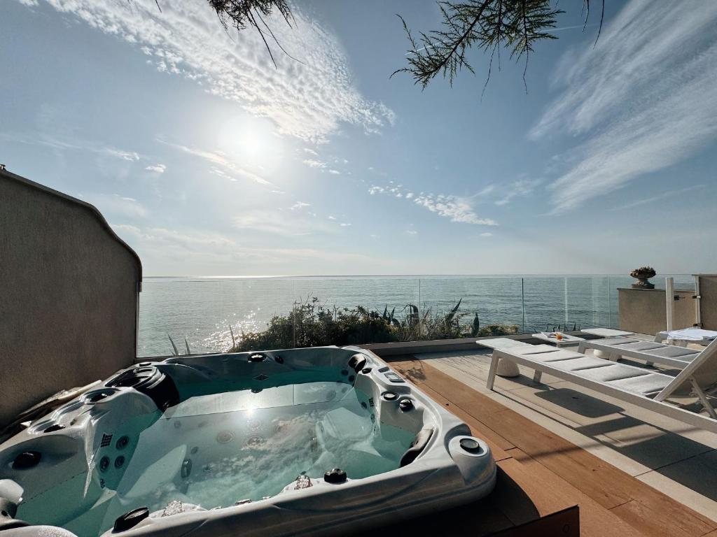 une baignoire jacuzzi sur une terrasse donnant sur l'océan dans l'établissement Villa la corniche pieds dans l eau, aux Issambres